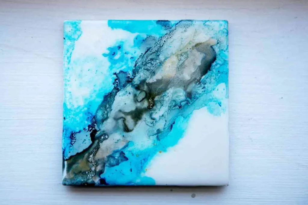 Ceramic drink coaster decorated with paint pouring technique