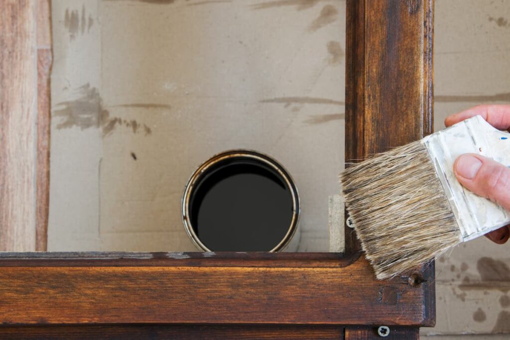 painting a table with a can of polyurethane