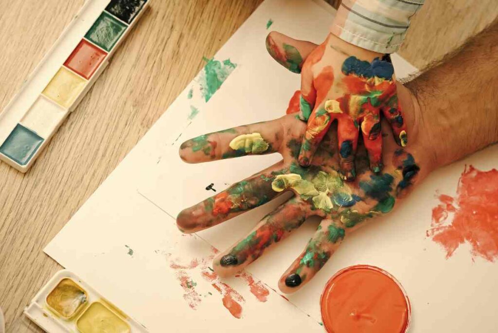 Adult and child's hands covered in paint for crafting