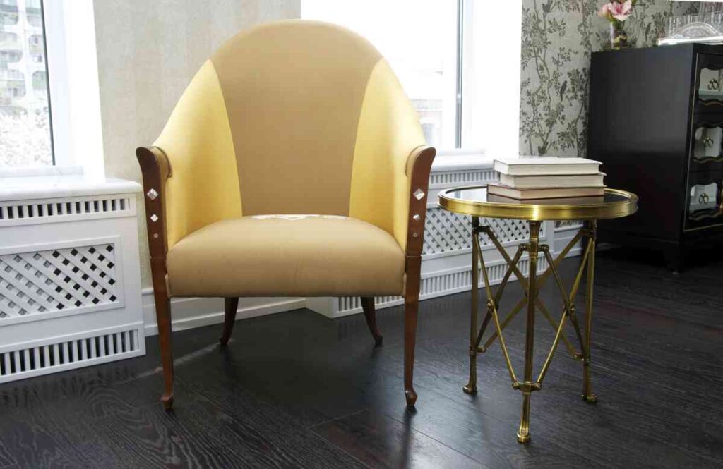 Tan and cream upholstered chair with a gold accent side table