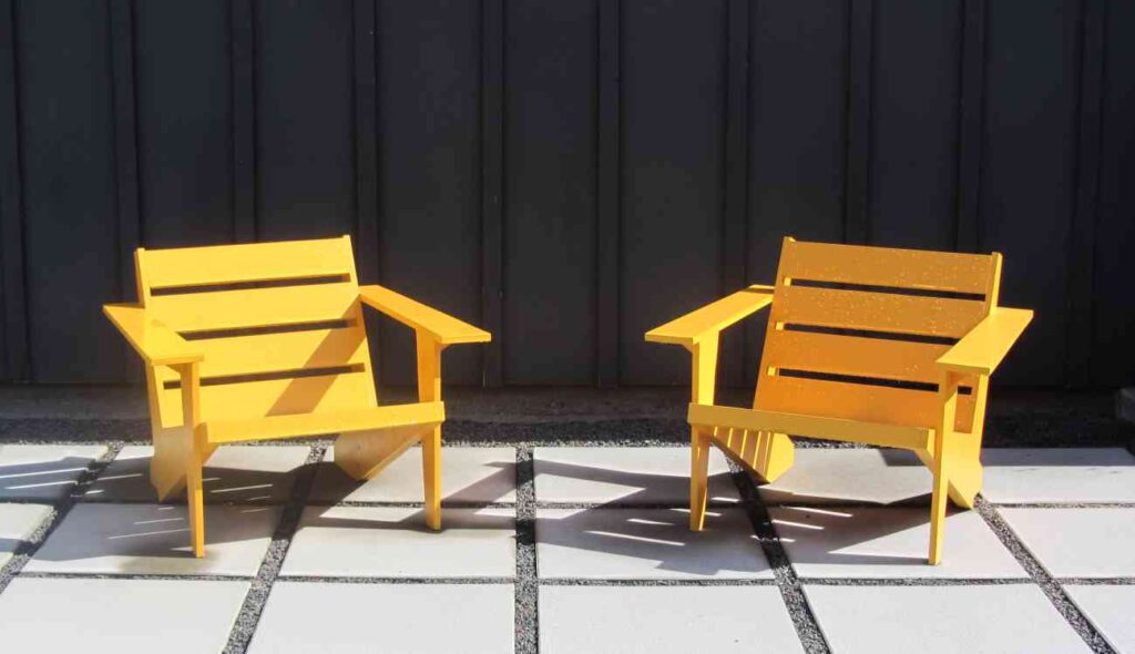 Two bright yellow chairs on a white tile patio