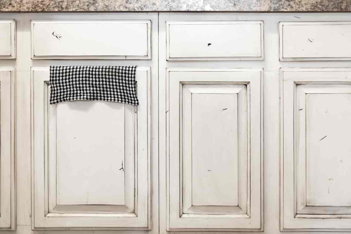 Distressing bathroom cabinets with white paint and sanding