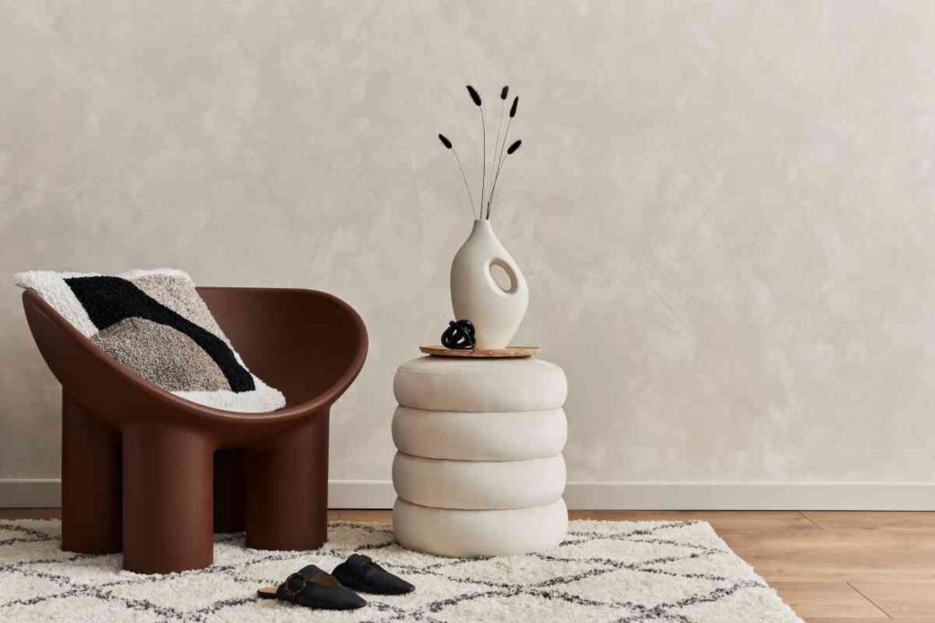 Using a backdrop to stage a chair and end table with a vase of flowers