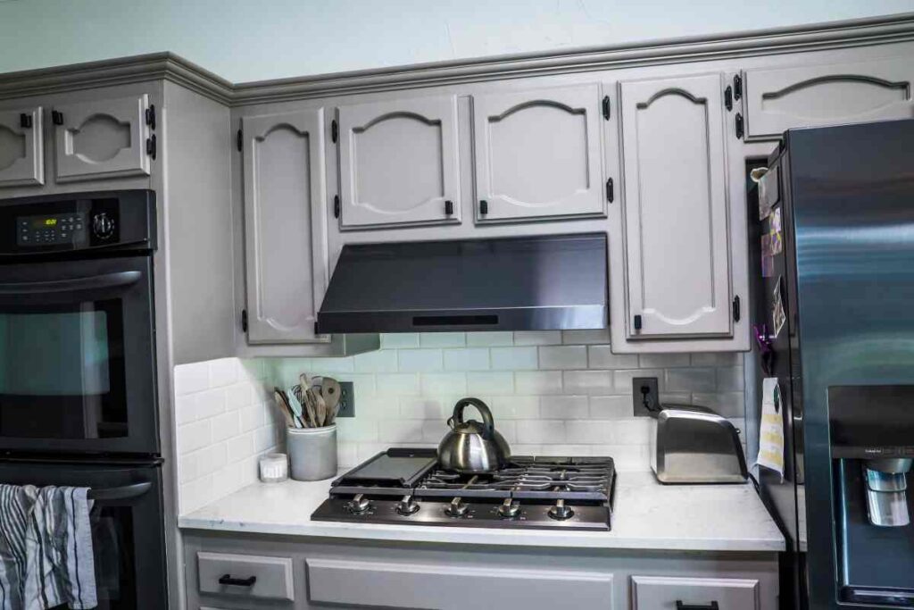 Kitchen cabinets painted grey with black appliances