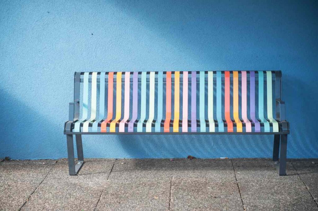 Outdoor metal bench painted in fun pastel colors