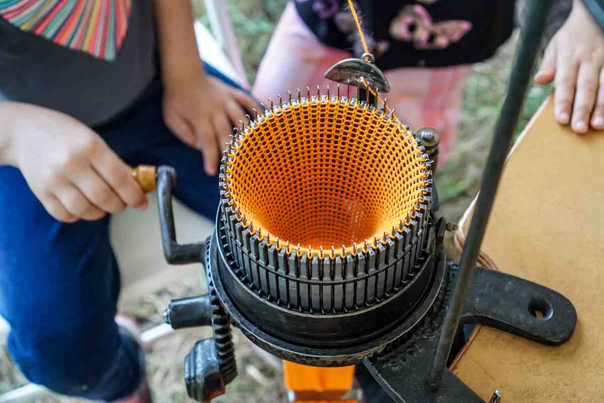 Close up of person using the best knitting machine with yellow yarn