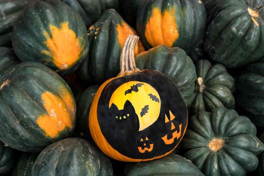 Using stencils to paint a halloween scene on a pumpkin