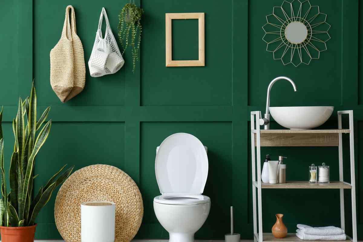 Dark green bathroom walls with white and natural accents is one of the best paint colors for bathrooms