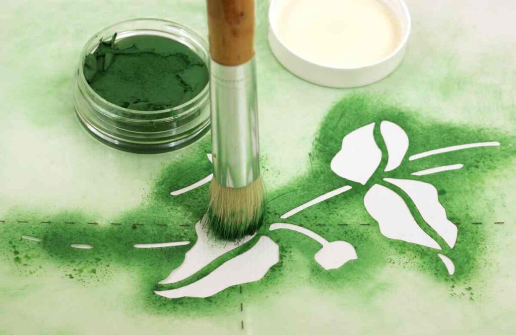 Leaf stencil and green paint showing how to paint with stencils