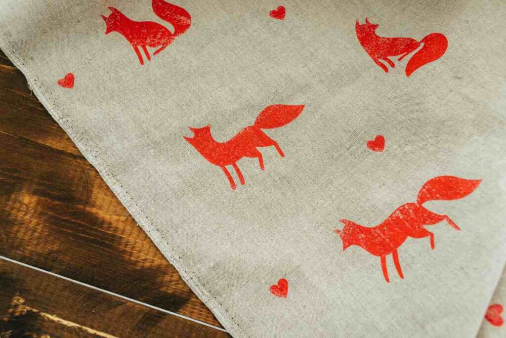 Muslin fabric stenciled with orange foxes and hearts