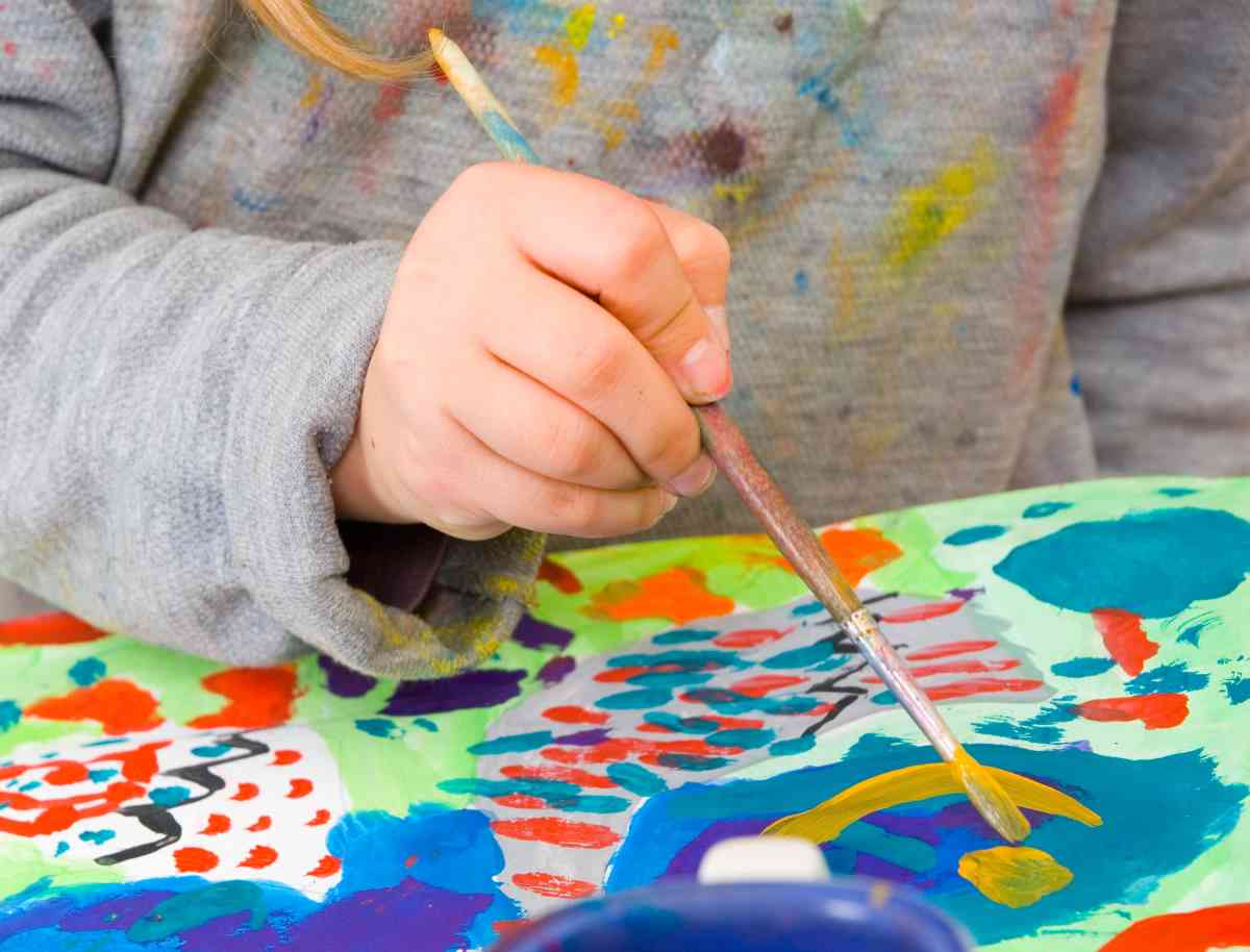 Child painting a picture at a kids craft table