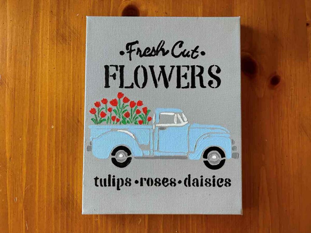 Fresh cut flowers stencil with blue truck painted on a canvas