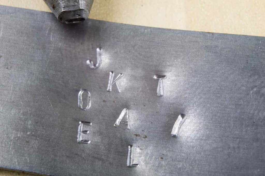 Practicing stamping metal jewelry on a scrap piece of metal
