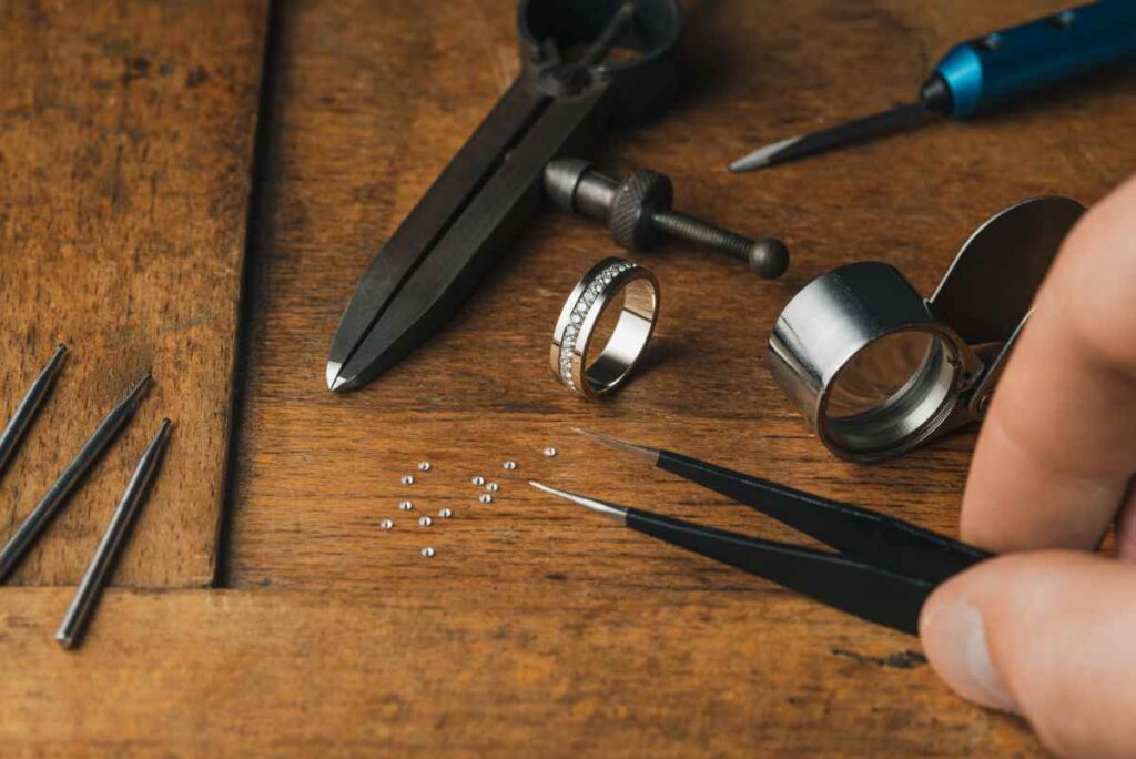 Jeweler's tools, a ring, and diamonds on a jeweler's bench
