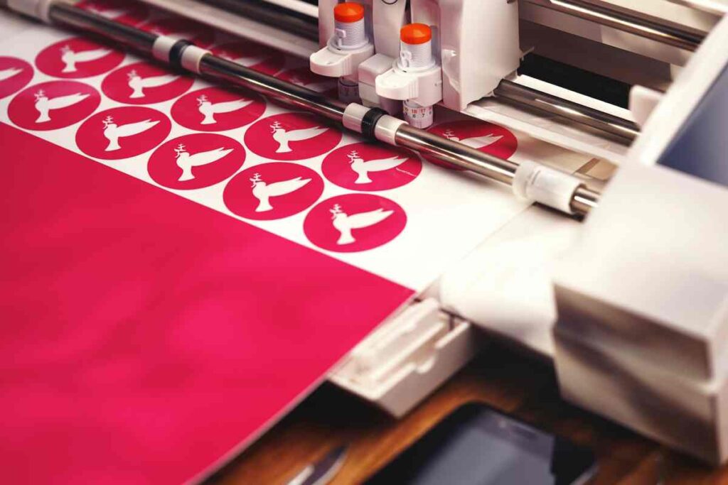 Doves being cut out of pink vinyl on a vinyl cutting machine