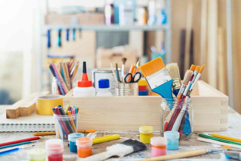 Paintbrushes, paints, and other supplies you'll find on crafting cabinets with tables