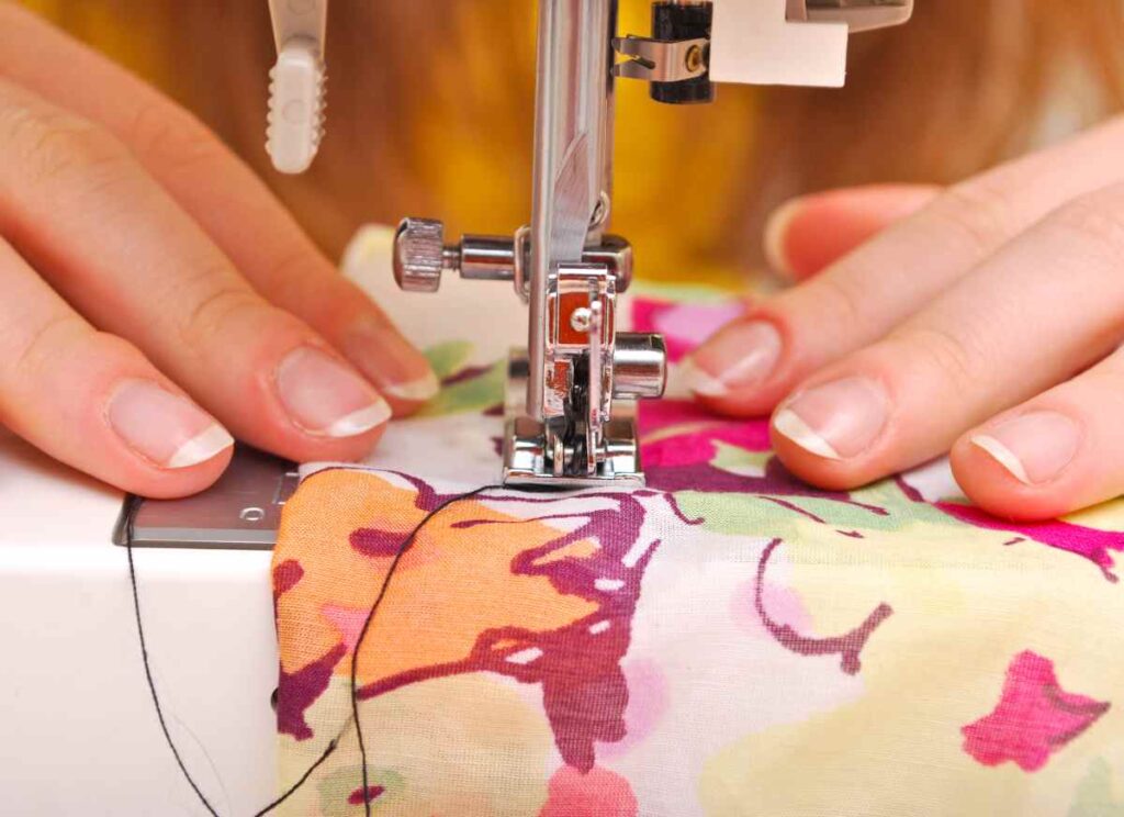 A woman using the best sewing machine for quilting to stitch a quilt