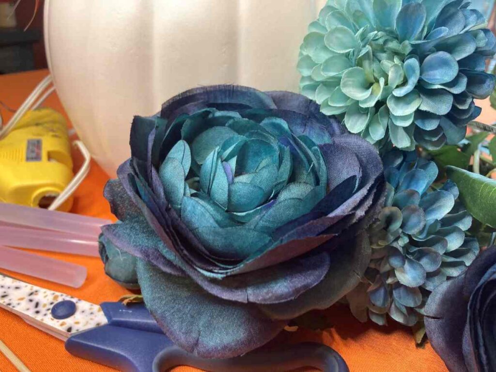 Flowers, pumpkin, and scissors to create a fall centerpiece