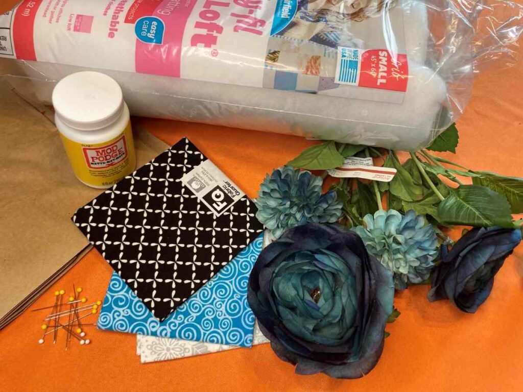 Fabric, flowers, batting, and more are needed to create a fabric pumpkin