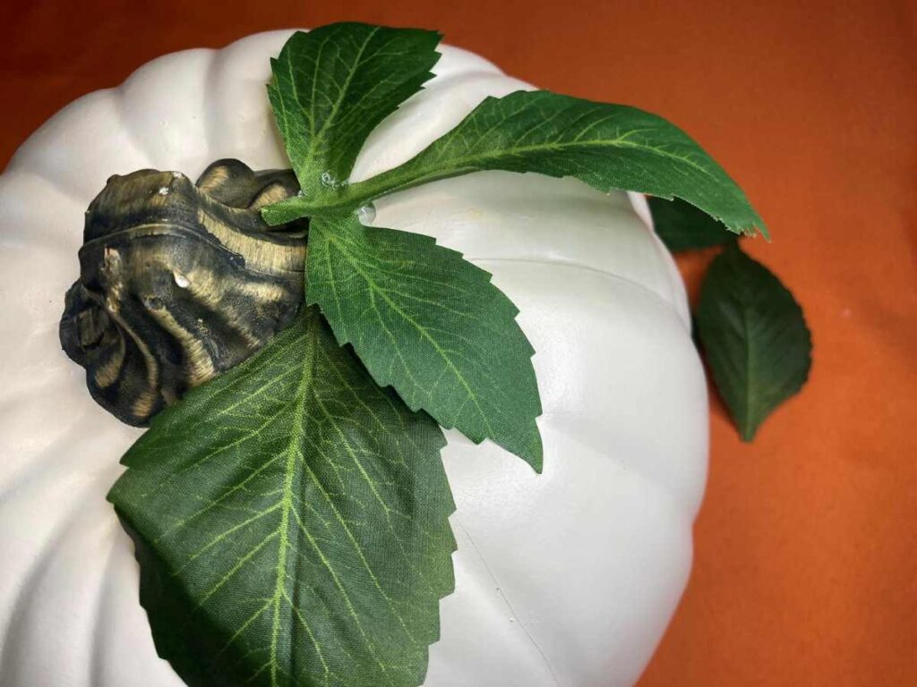 Faux leaves glued to a pumpkin stem
