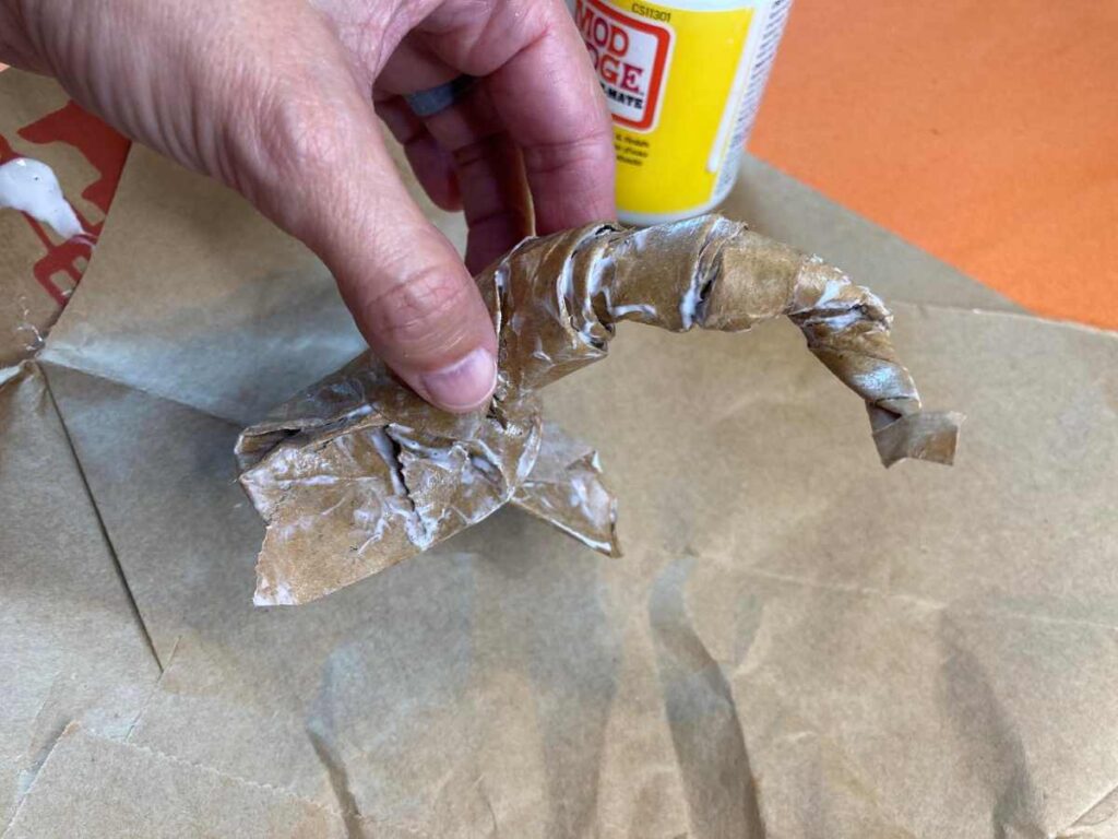 Brown paper bag painted with Mod Podge and twisted to look like the stem of a pumpkin