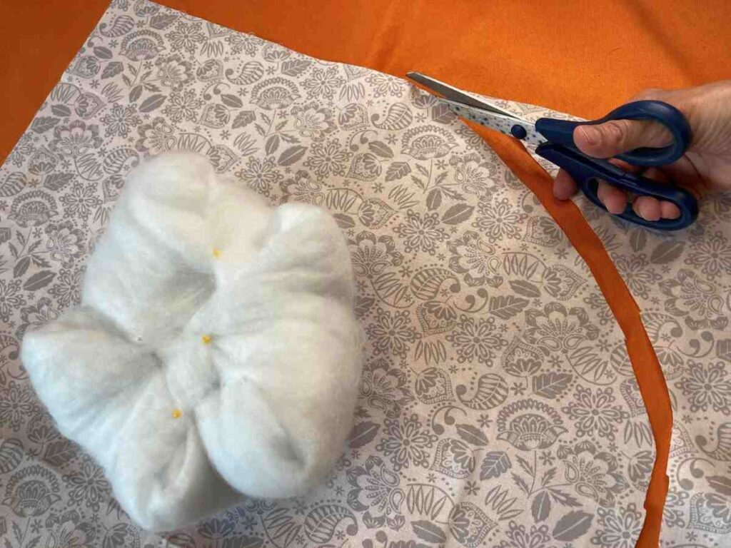Cutting fabric to the wrap around a roll of batting