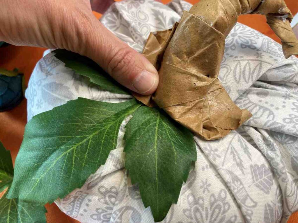 Attaching greenery to a fabric pumpkin