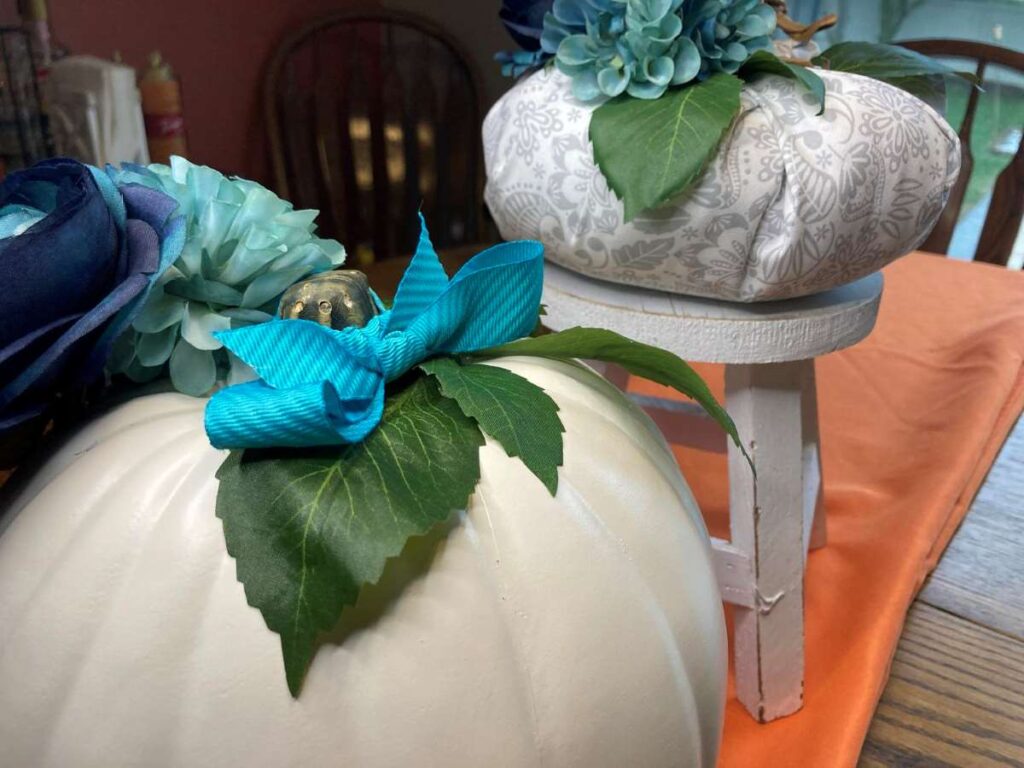 Creating a fall table centerpiece with pumpkins and blue flowers