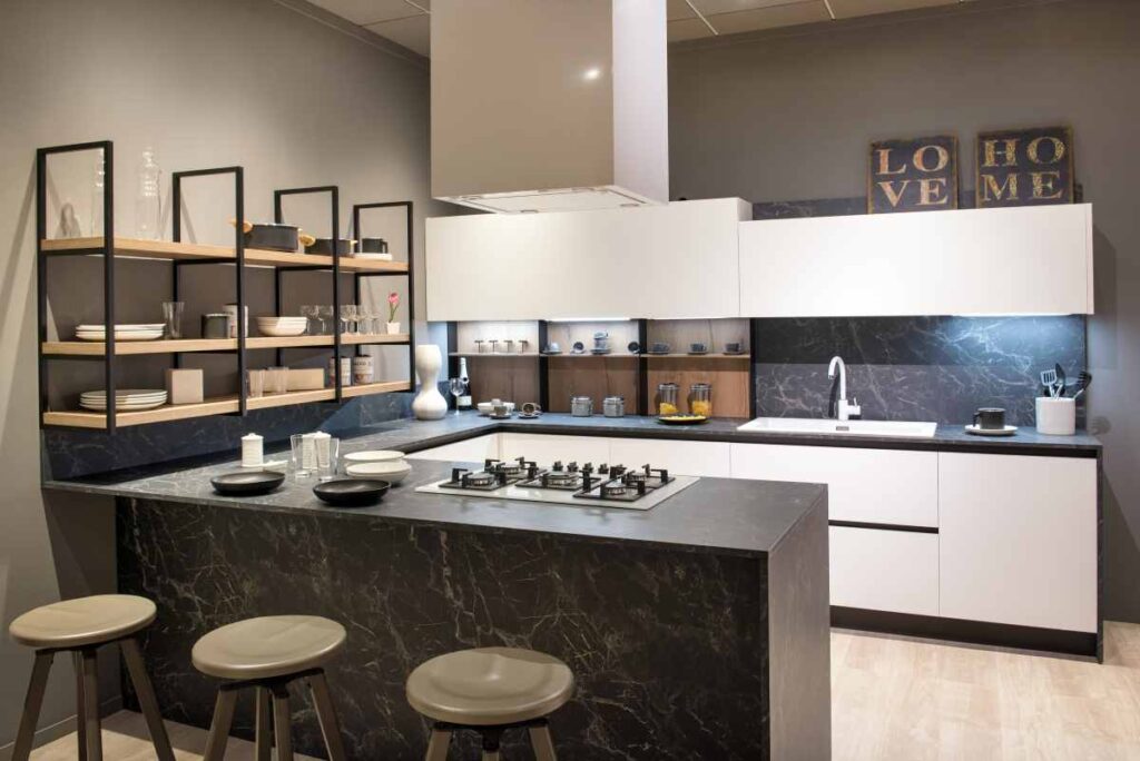 Kitchen with white cabinets, black countertops, and open shelving 