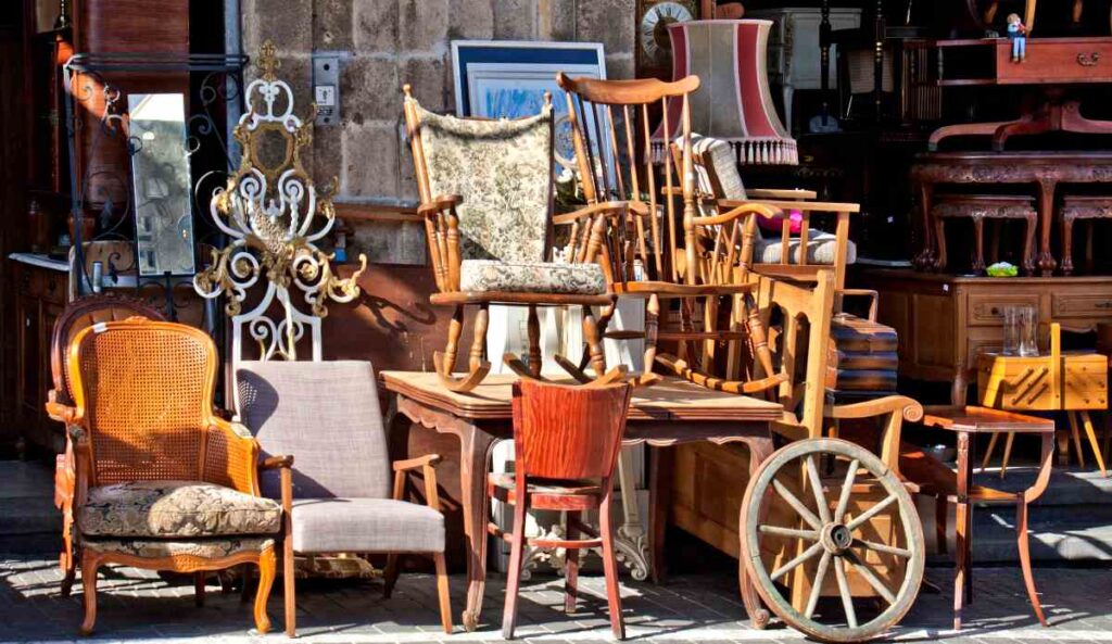 Several pieces of antique furniture including chairs and wagon wheels