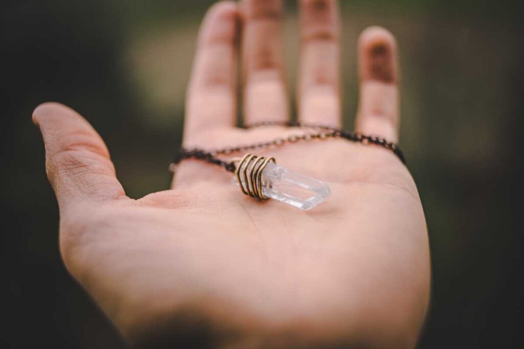 Person holding a crystal necklace