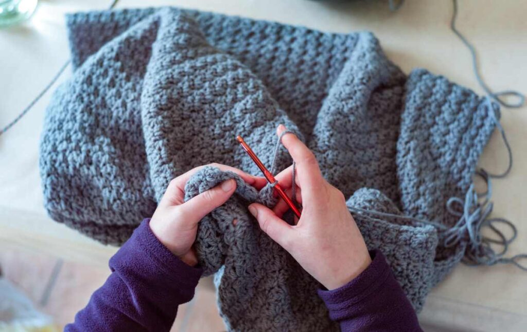 A woman's hands showing how to crochet a blanket