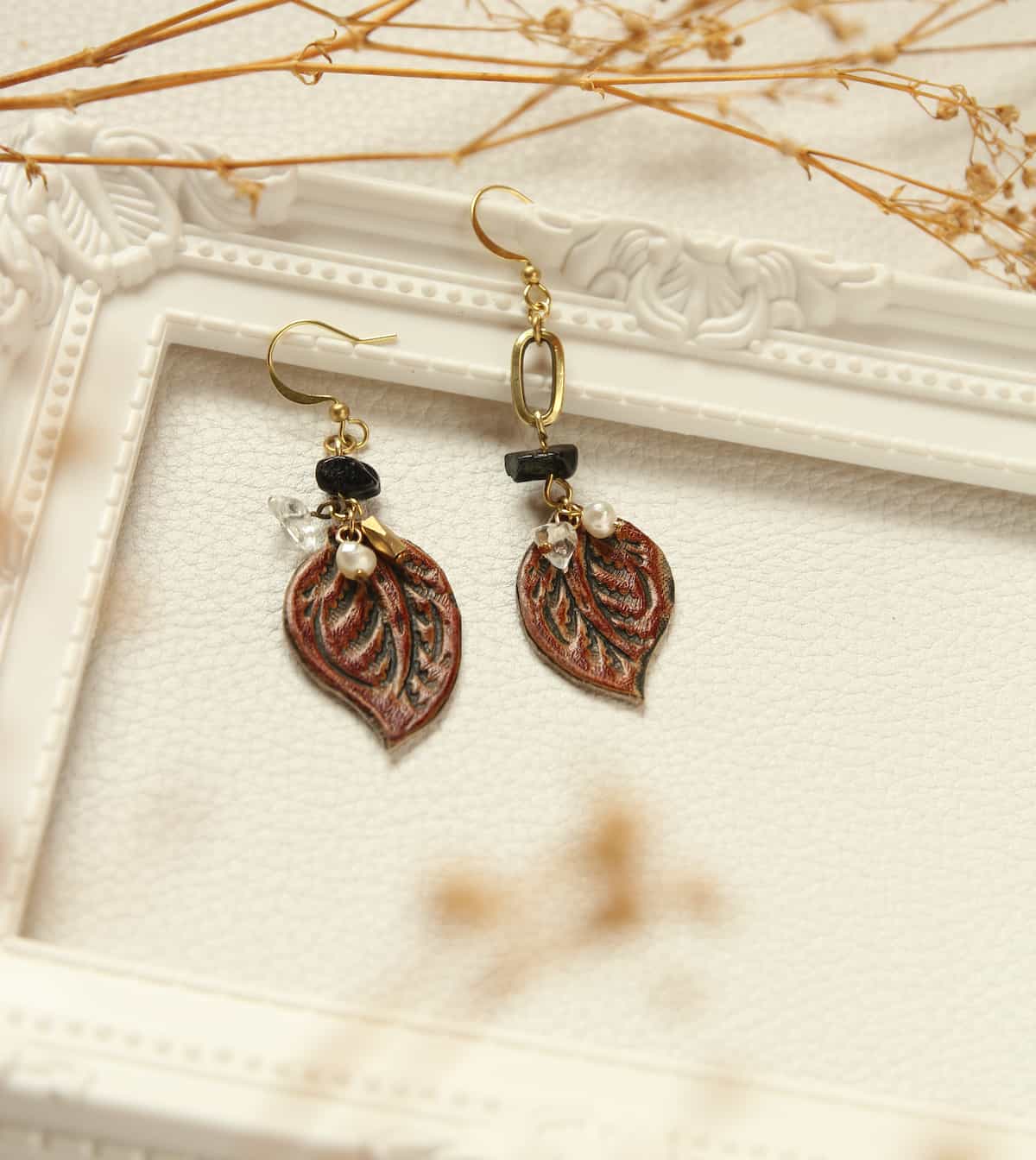 A pair of leaf-shaped leather earrings.