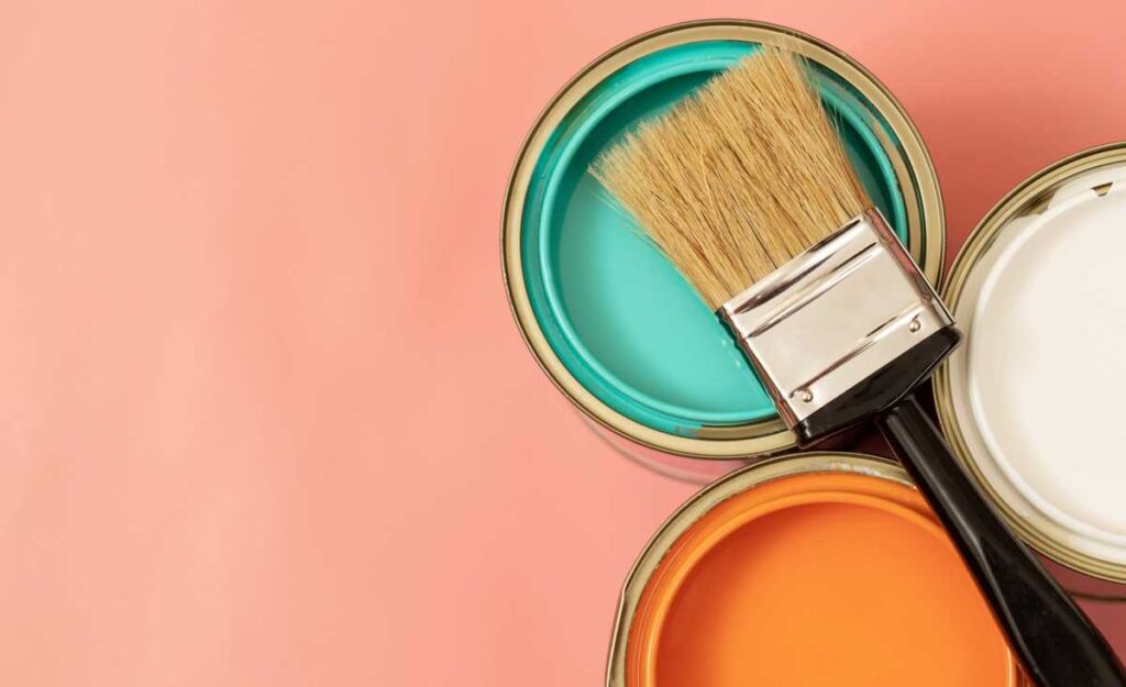 Cans of colorful zero VOC paint with a paintbrush