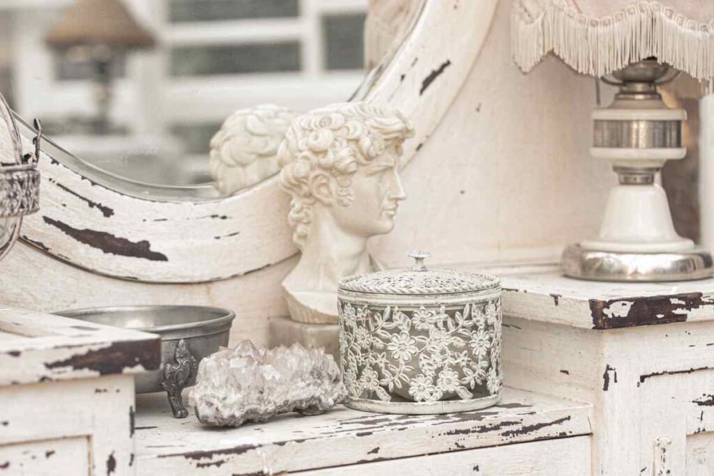 White vanity table with white mirror and white accessories using a technique for distressing white furniture