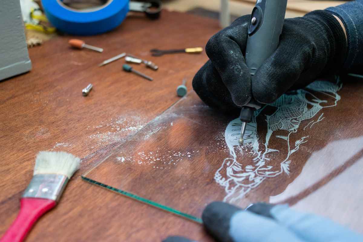 A man using a rotary tool for engraving onto glass
