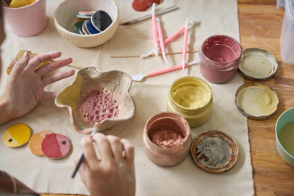 Applying pottery glaze with detail brushes