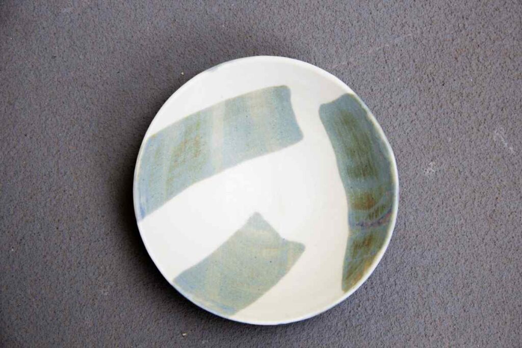 Pottery plate with color blocked glazing in shades of green