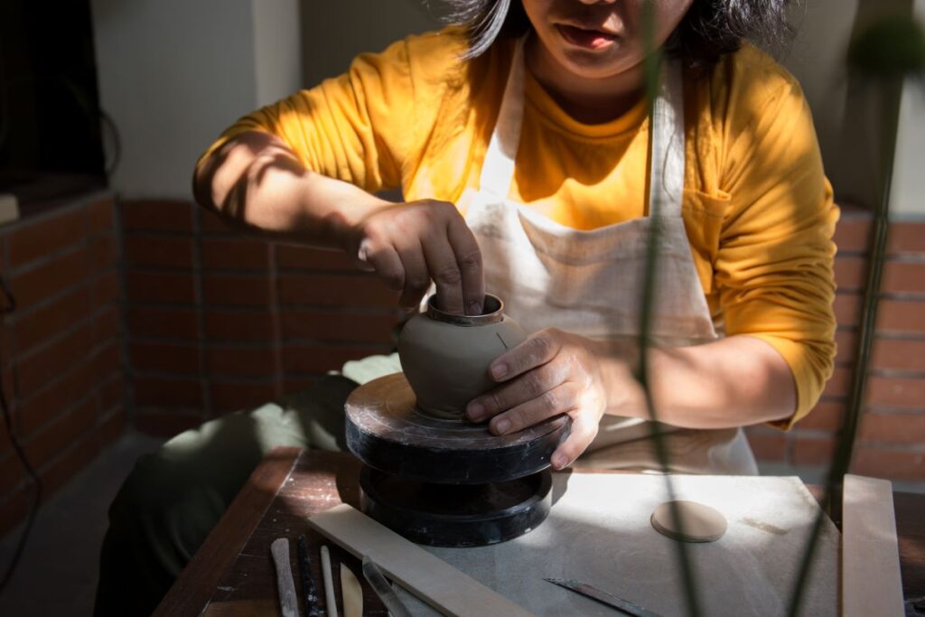 Young woman using a pottery wheel for beginners