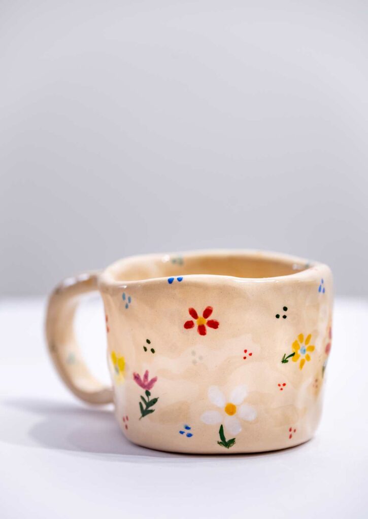 Pottery mug decorated with hand painted daisies