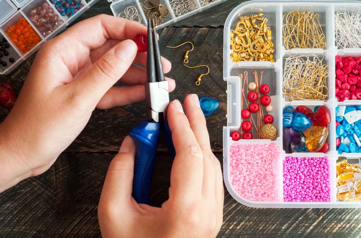 Person using a jewelry making kit and pliers to make a piece of jewelry
