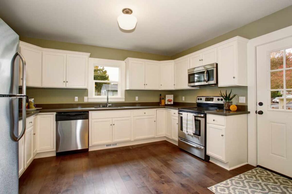 Kitchen cabinets painted white with green walls
