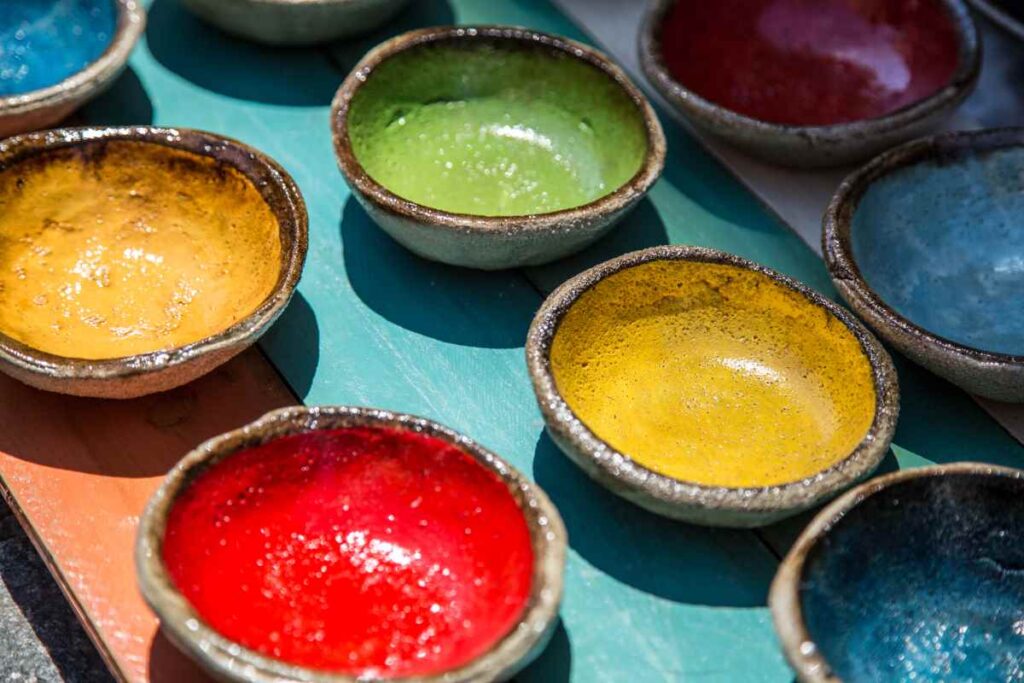 Black pottery bowls with colorful inner glazes in red, yellow, and green