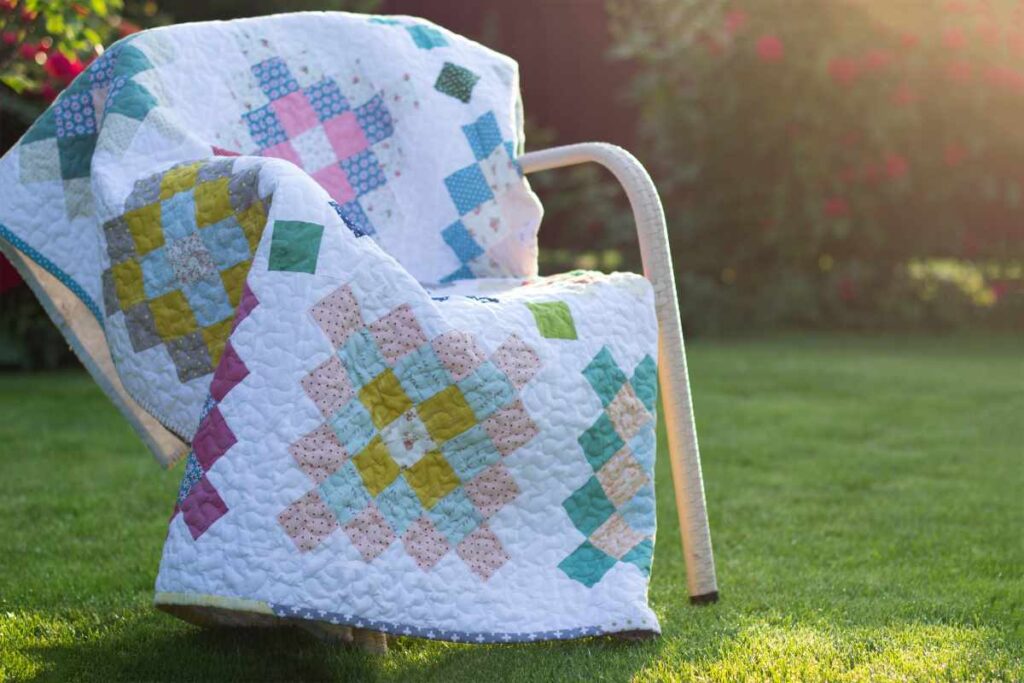 Completed quilt draped over a chair outside