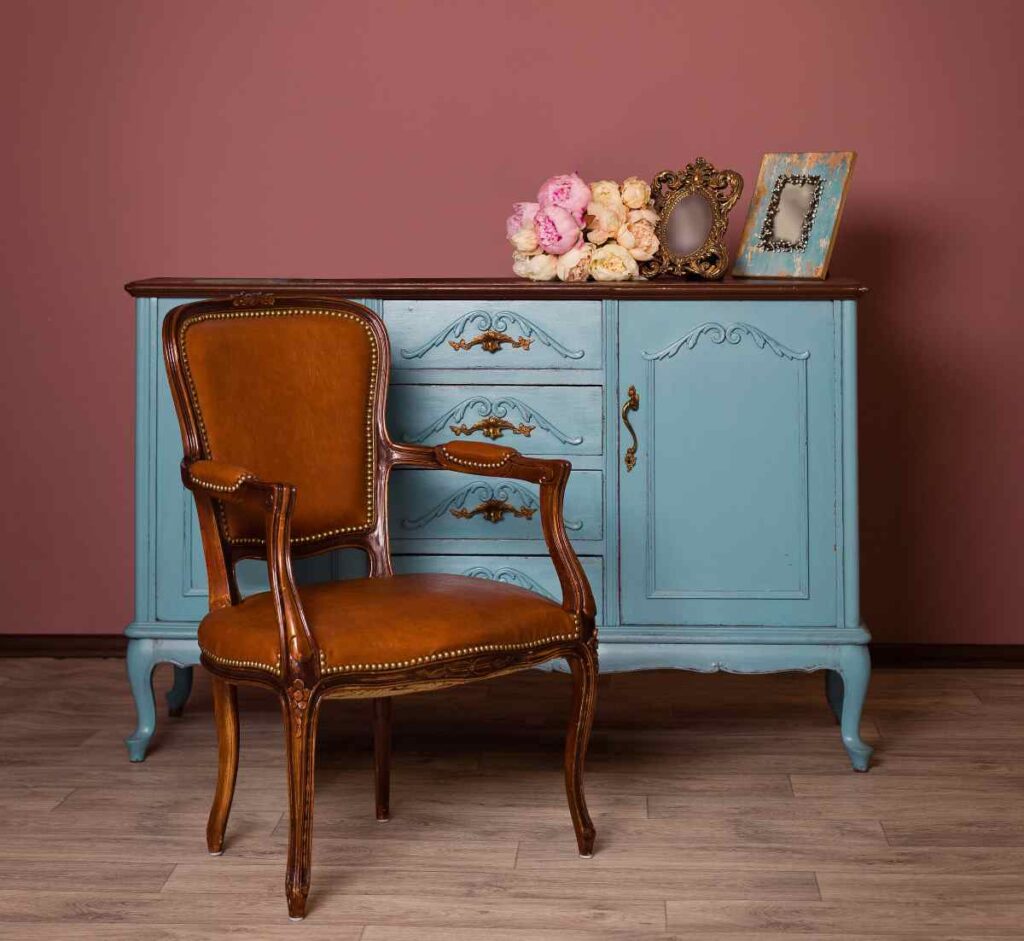 An antique dresser refurbished blue and an antique chair kept natural