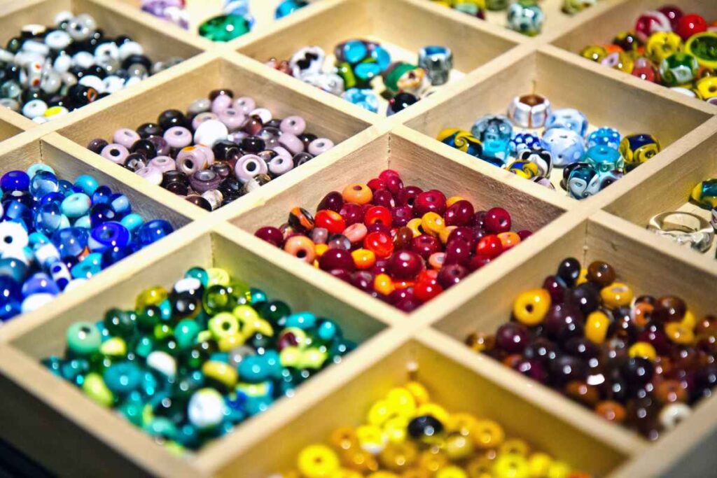 Different types of glass beads in organizer trays ready to be made into jewelry