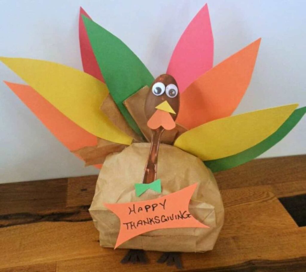 Thanksgiving turkey craft made out of a paper bag and construction paper