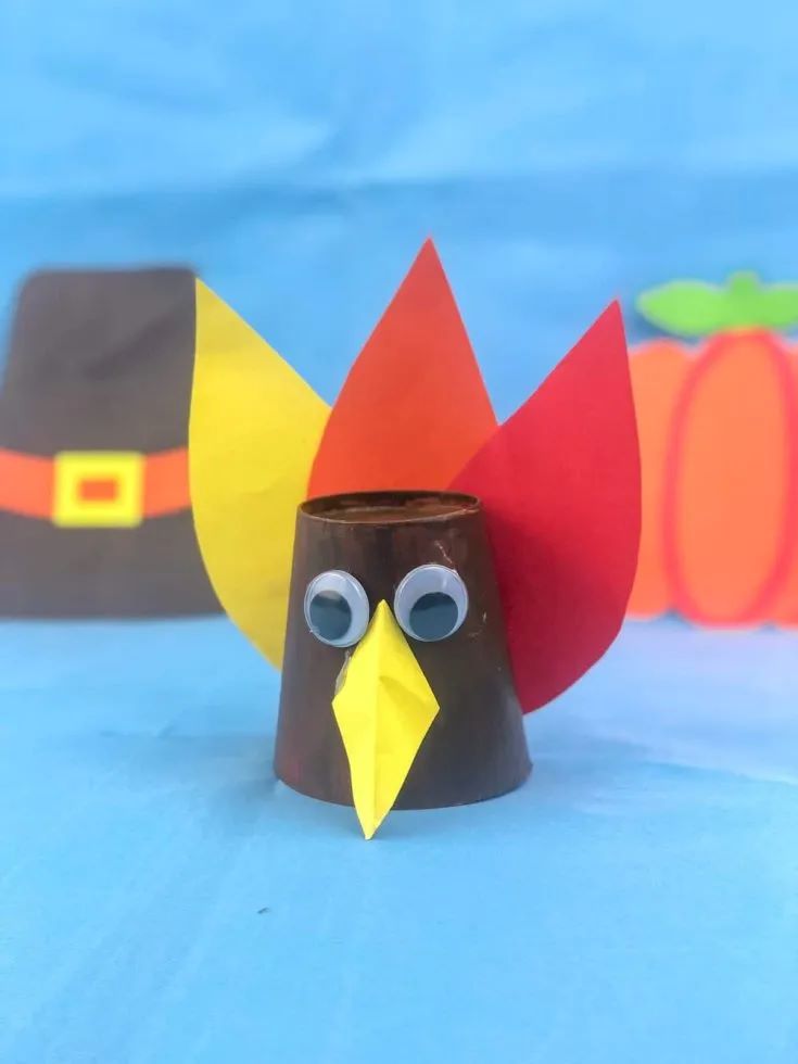 A paper cup, googly eyes, and some construction paper made into a Thanksgiving turkey