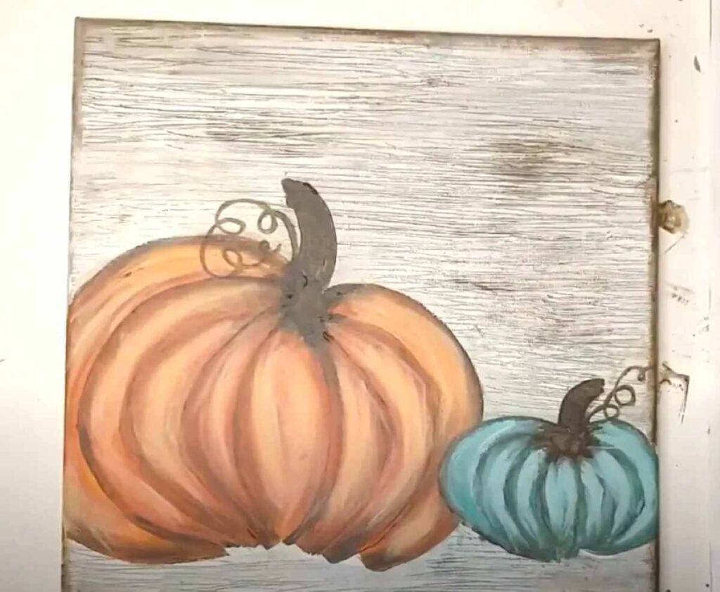 Orange and teal pumpkins painted on canvas