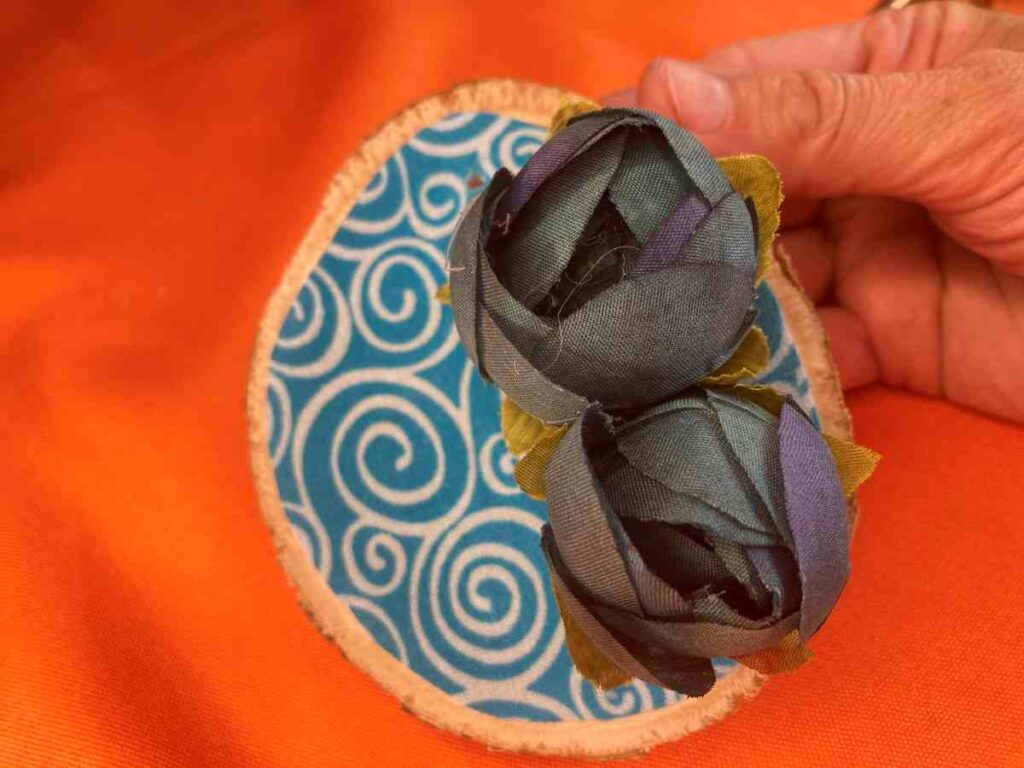 Adding silk flowers to a wood slice ornament